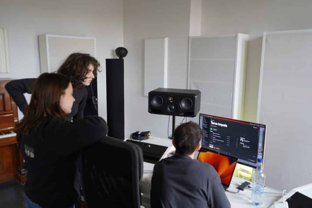 Three BIMM Berlin students in front of a computer