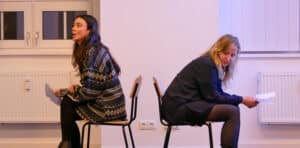 Two students sitting back to back in acting masterclass