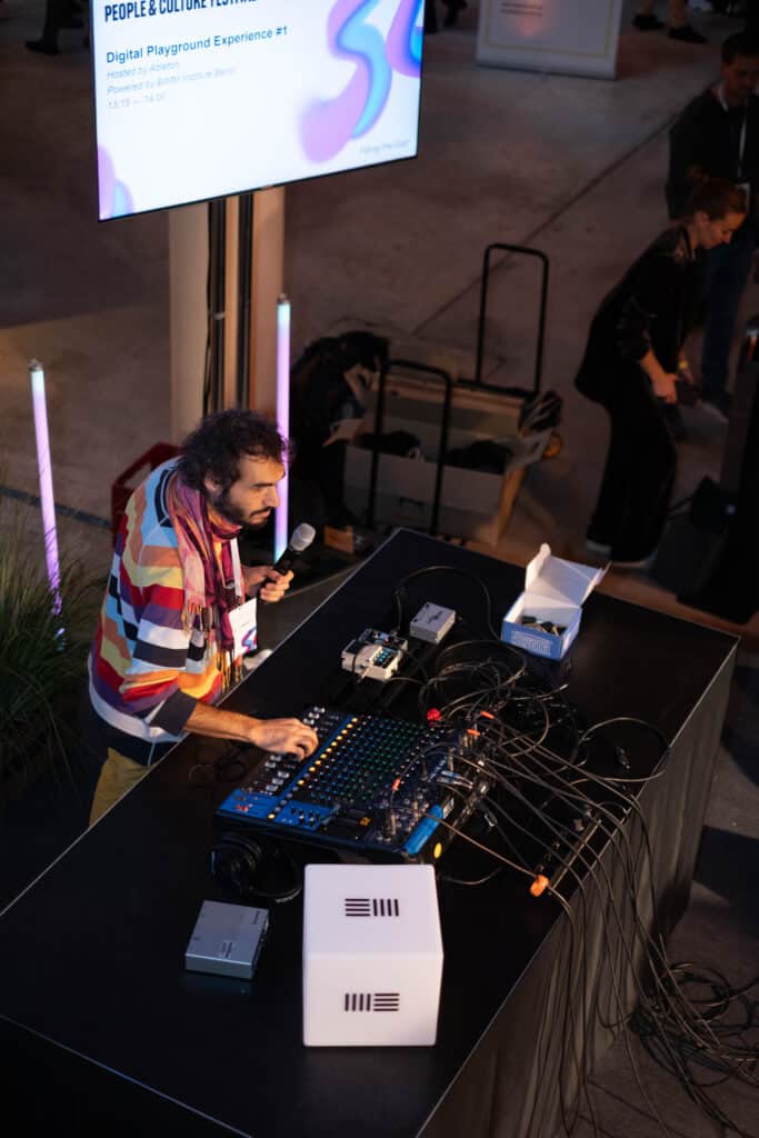 BIMM University Berlin lecturer Sjoerd van der Sanden presents the Albeton Digital Playground Experience at People & Culture Festival 2023. Sjoerd stands behind a mixing desk.