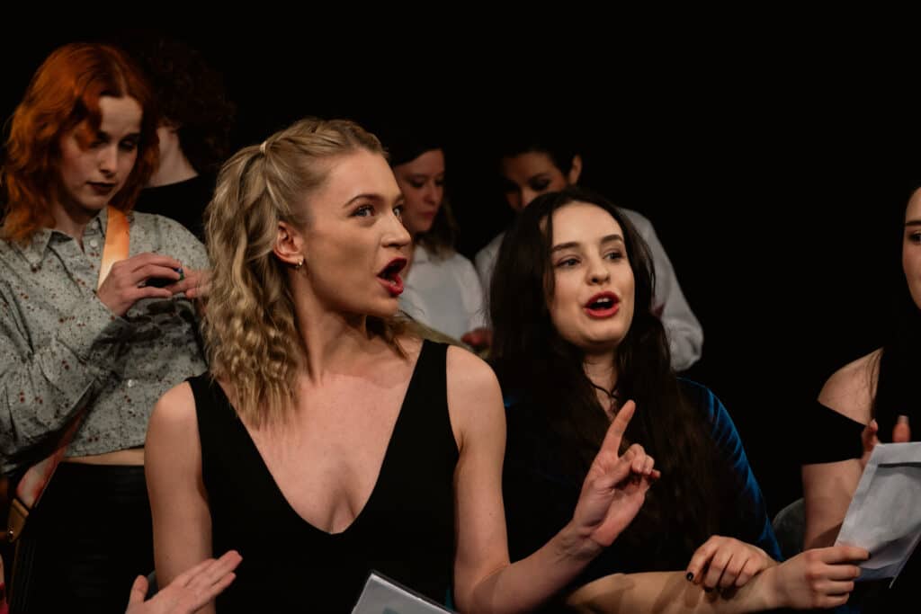 Female actings students reciting dialogue.